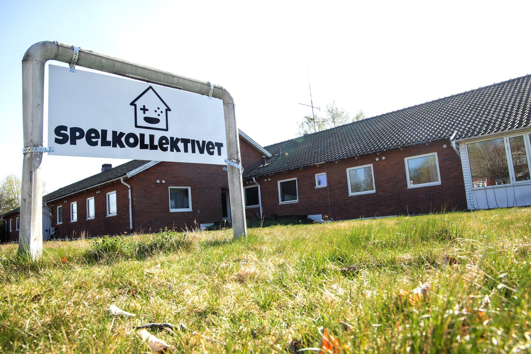 Photograph of Spelkollektivet sign with building in background.